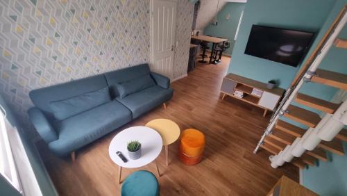 ein Wohnzimmer mit einem blauen Sofa und einem Tisch in der Unterkunft Haus Erdmann in Dahn