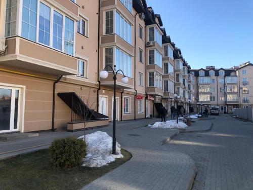 a city street with snow on the sidewalk and buildings at GIL Apartments, Volodimirskaja 90.212 - Majetok Bozdosh in Uzhhorod