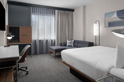 a hotel room with a bed and a desk at Courtyard by Marriott Calgary Downtown in Calgary