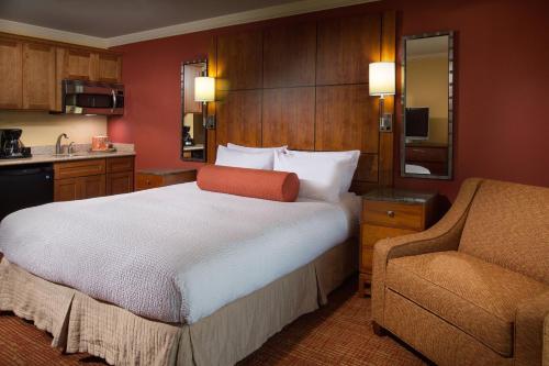 a hotel room with a bed and a chair at Residence Inn by Marriott St. Petersburg Treasure Island in St Pete Beach