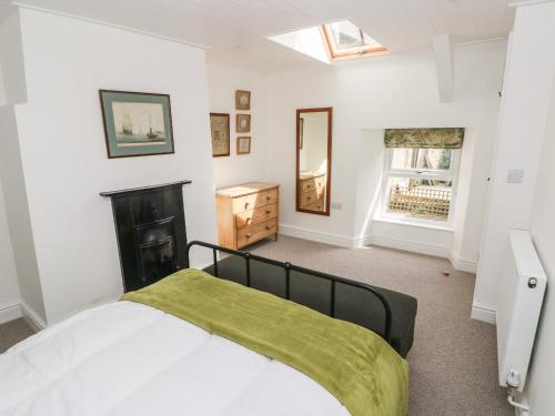 a bedroom with a bed with a green blanket on it at 10 Westgate Hill in Pembroke