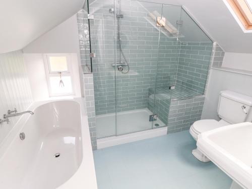 a bathroom with a shower and a tub and a toilet at 10 Westgate Hill in Pembroke