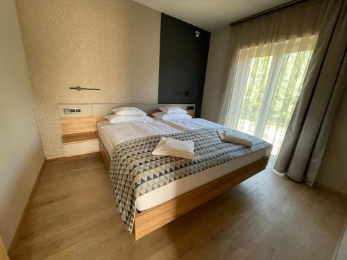 1 dormitorio con cama y ventana grande en Optimus Residence en Balatonföldvár