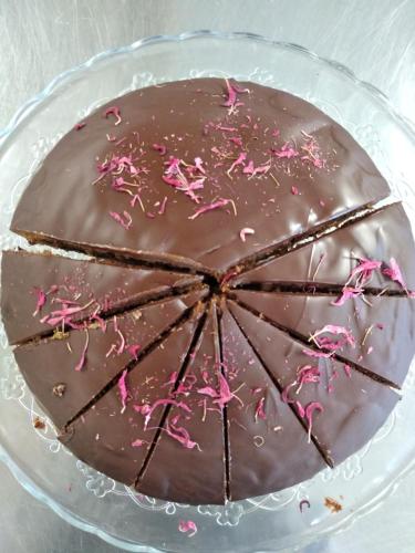 a chocolate cake with pink sprinkles on a glass plate at Eco-Green Fiores Agriturismo in Vigo di Fassa