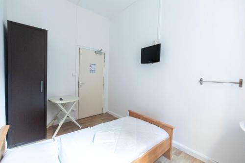- une petite chambre avec un lit et une télévision dans l'établissement Hôtel Le Paris Brest, à Lens