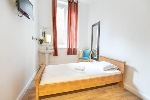 małą sypialnię z łóżkiem i lustrem w obiekcie Hôtel Le Paris Brest w mieście Lens