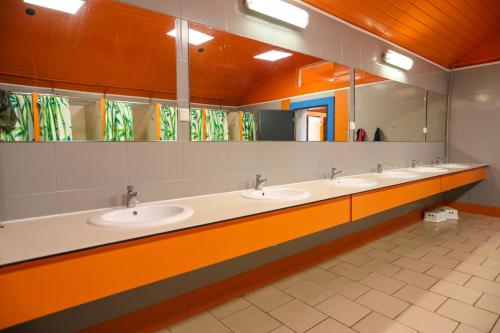 a bathroom with three sinks and a row of mirrors at Letnia Baza SnowShow na Półwyspie Helskim - Maszoperia SUN4HEL in Jastarnia