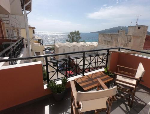 a balcony with a table and chairs and the ocean at Arty Loft with Sea & City Views in Zakynthos Town