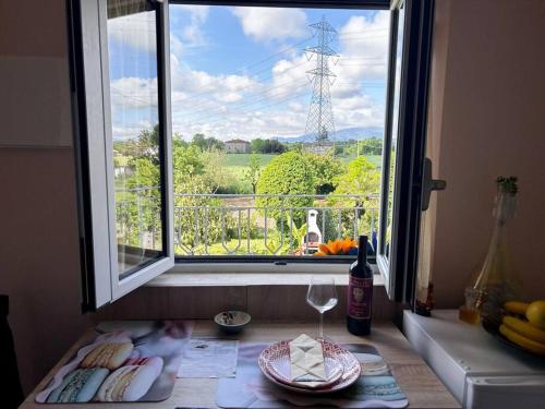 ein Fenster mit einem Teller Essen und einem Weinglas in der Unterkunft (Via Francigena) La Casa Di Danilo in Spianate