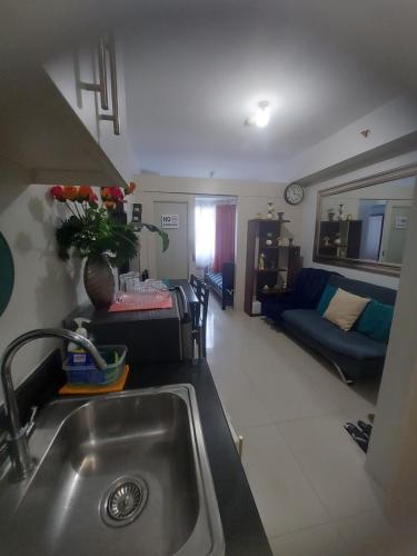 a kitchen with a sink and a living room with a couch at Cozy House in Manila
