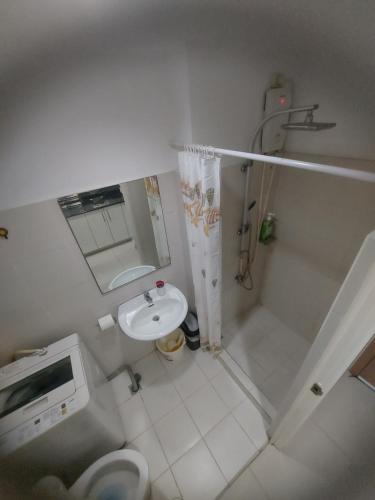 a small bathroom with a toilet and a sink at Cozy House in Manila