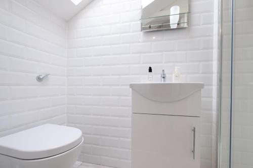 a white bathroom with a toilet and a sink at Cottage 420 - Clifden in Clifden