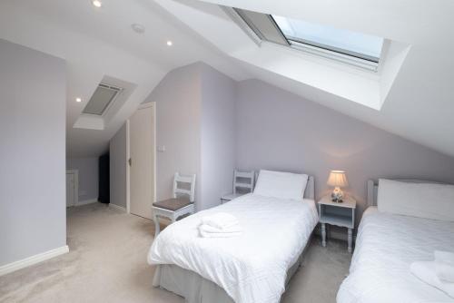 two beds in a white room with a window at Cottage 420 - Clifden in Clifden