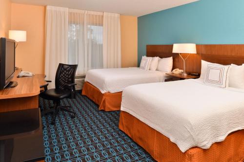 een hotelkamer met 2 bedden, een bureau en een televisie bij Fairfield Inn & Suites Cleveland Avon in Avon