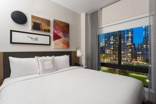 Un dormitorio con una gran cama blanca y una ventana en Fairfield Inn & Suites by Marriott New York Manhattan/Central Park, en Nueva York