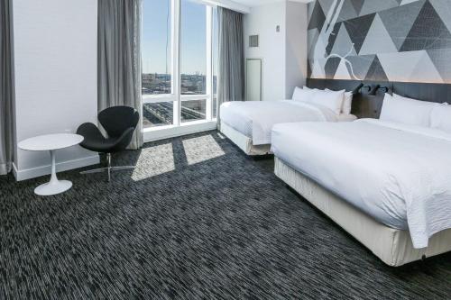 a hotel room with two beds and a desk at Courtyard by Marriott Long Island City/New York Manhattan View in Queens