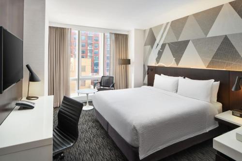 a hotel room with a bed and a desk at Courtyard by Marriott Long Island City/New York Manhattan View in Queens