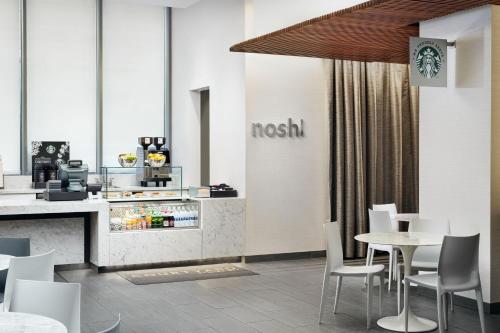 a restaurant with a table and chairs and a counter at Courtyard by Marriott Long Island City/New York Manhattan View in Queens