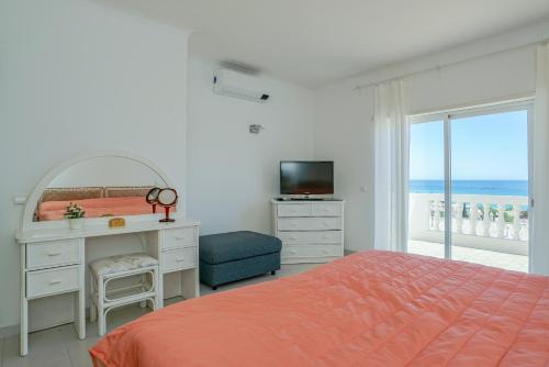 - une chambre avec un lit, un bureau et une télévision dans l'établissement Ramalhete panoramic view apartment, à Luz