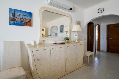 La salle de bains est pourvue d'un grand miroir et d'une commode. dans l'établissement Ramalhete panoramic view apartment, à Luz