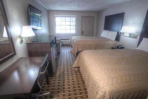 a hotel room with two beds and a desk at Amerivu Inn & Suites - Helen - Downtown in Helen