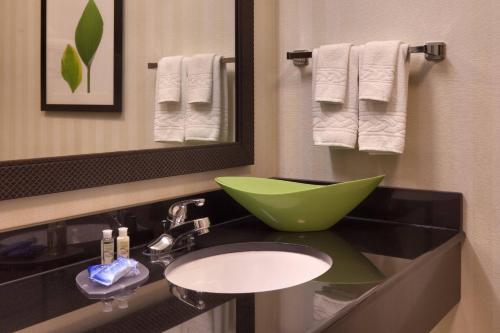 a bathroom with a sink and a mirror and towels at Fairfield Inn and Suites by Marriott Laramie in Laramie