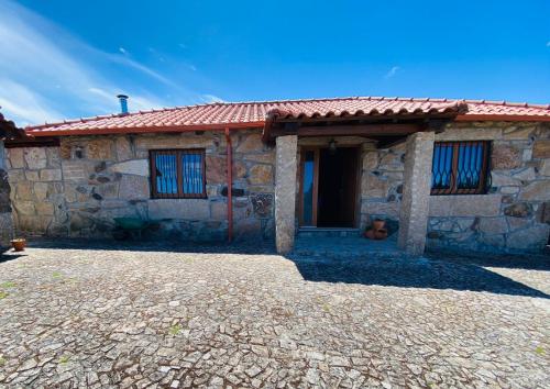 a small stone house with a red roof at Quinta do Mirante in Celorico de Basto