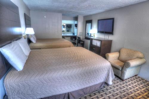 a hotel room with two beds and a chair at Amerivu Inn & Suites - Helen - Downtown in Helen