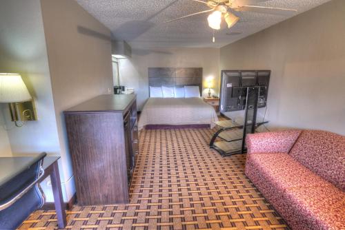 a hotel room with a bed and a couch at Amerivu Inn & Suites - Helen - Downtown in Helen