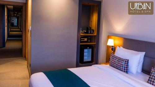 a bed in a hotel room with a bed sidx sidx sidx at Urban Hotel & Spa in Kenitra