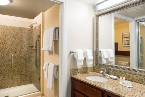 uma casa de banho com um lavatório, um chuveiro e um espelho. em Residence Inn Long Beach Downtown em Long Beach