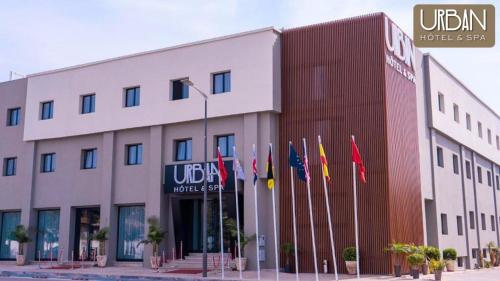 Um edifício com um monte de bandeiras à frente. em Urban Hotel & Spa em Kenitra