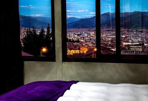 庫斯科的住宿－Casa valicha，一间带2扇窗户的卧室,享有城市美景