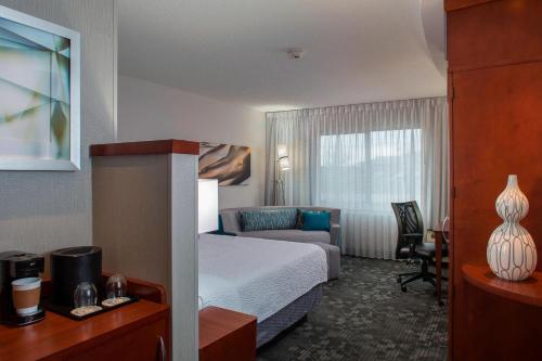 a hotel room with a bed and a desk and a chair at Courtyard by Marriott Nashville Goodlettsville in Goodlettsville