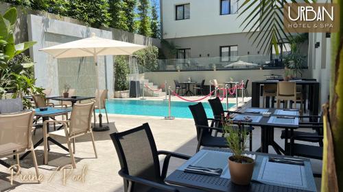 an outdoor patio with tables and chairs and a pool at Urban Hotel & Spa in Kenitra