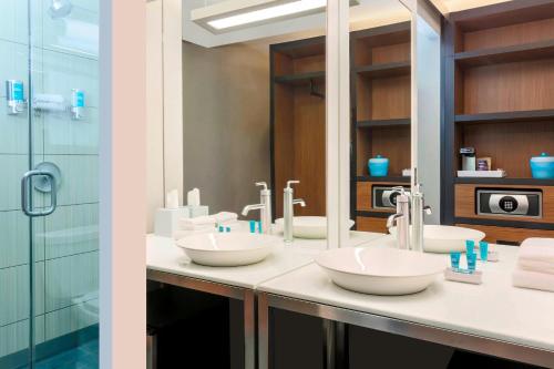 a bathroom with two sinks and a shower at Aloft Harlem in New York