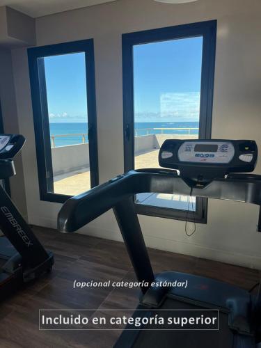 a gym with a treadmill and a view of the ocean at Hotel AATRAC in Mar del Plata