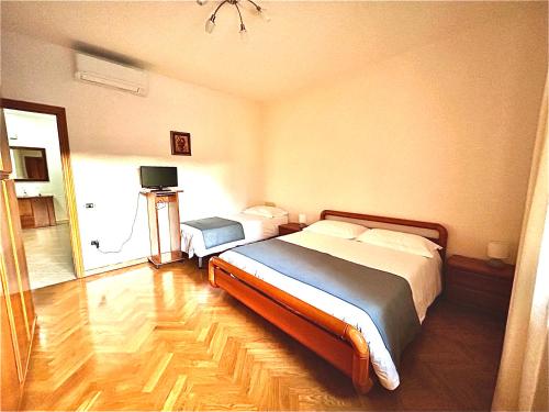 a bedroom with two beds and a television in it at Appartamento L'arancio in Recanati