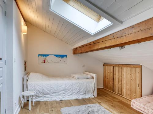 a bedroom with a bed and a skylight at Appartement rénové 2 chambres, proche centre Megève, lumineux, parking, animaux acceptés - FR-1-453-296 in Megève