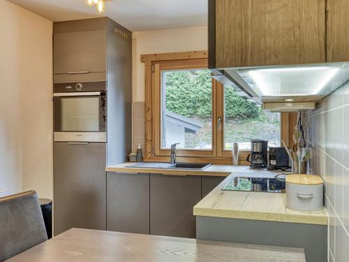 une cuisine avec un évier et une fenêtre dans l'établissement Appartement rénové 2 chambres, proche centre Megève, lumineux, parking, animaux acceptés - FR-1-453-296, à Megève