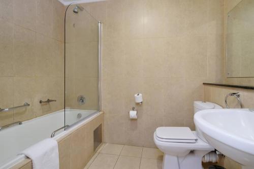 a bathroom with a toilet and a sink and a shower at Protea Hotel by Marriott Polokwane Landmark in Polokwane