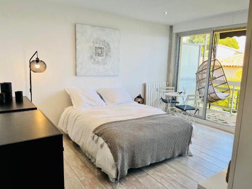 een slaapkamer met een bed en een tafel en een balkon bij Charmant studio avec terrasse vue mer à 50 m in Sainte-Maxime
