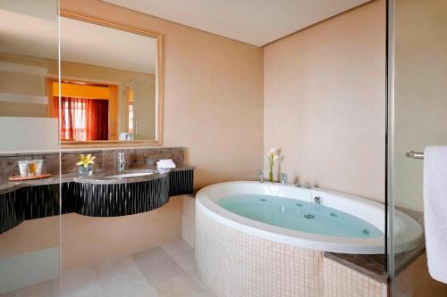 a bathroom with a tub and a sink at Petra Marriott Hotel in Wadi Musa