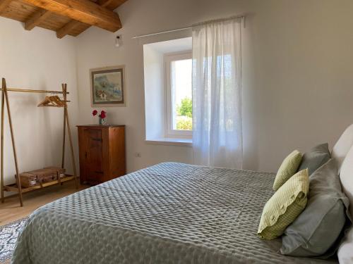 sypialnia z dużym łóżkiem i oknem w obiekcie B&B Casa Trambasore w mieście Caprino Veronese