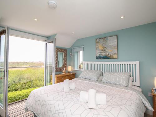 a bedroom with a large bed and a large window at Blue Waters in Weymouth