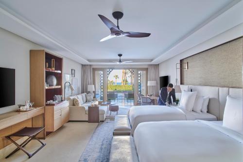 a hotel room with two beds and a living room at Four Seasons Resort Sharm El Sheikh in Sharm El Sheikh