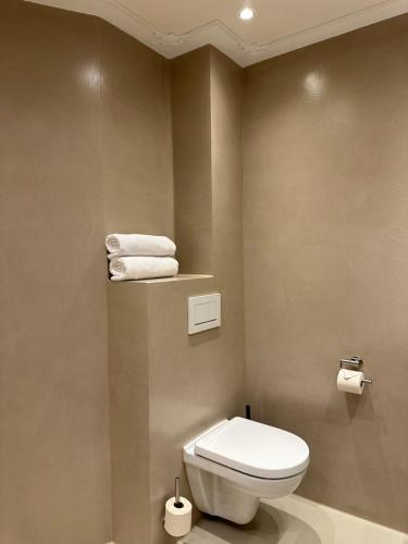 a bathroom with a toilet and towels on a wall at Hotel Grand Canal in Delft