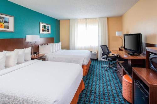 a hotel room with two beds and a flat screen tv at Fairfield Inn & Suites by Marriott Branson in Branson