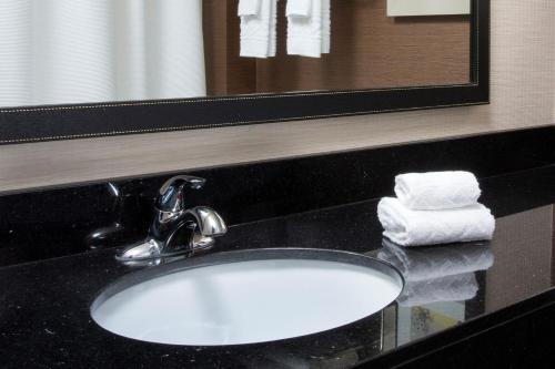 - Baño con lavabo blanco, espejo y toallas en Fairfield Inn & Suites by Marriott Branson, en Branson