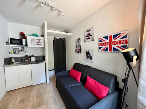 a living room with a black couch and pink pillows at STUDIO Av MARX DORMOY CLERMONT CENTRE B in Clermont-Ferrand